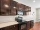 Modern kitchen with dark cabinetry, granite countertops, and stainless steel appliances at 14143 Wake Robin Dr, Brooksville, FL 34604