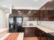 Modern kitchen with dark cabinetry, granite countertops, and stainless steel appliances at 14143 Wake Robin Dr, Brooksville, FL 34604