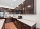 Modern kitchen with dark cabinetry, granite countertops, and stainless steel appliances at 14143 Wake Robin Dr, Brooksville, FL 34604