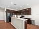 Modern kitchen with dark cabinetry, granite countertops, and stainless steel appliances at 14143 Wake Robin Dr, Brooksville, FL 34604