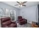 Relaxing sitting area with two leather recliners, ceiling fan, and large window at 1764 Blue Lake Ct, Tarpon Springs, FL 34689