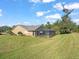 Home with fenced pool and screened enclosure, surrounded by lush landscaping at 19502 Forest Garden Ct, Brooksville, FL 34601