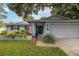 Gray house with American flag and landscaped yard at 2413 Hazelwood Ln, Clearwater, FL 33763