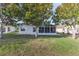 House with a large backyard, lush lawn, and screened sunroom at 262 Hartford Ct, Spring Hill, FL 34609