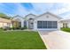 Tan one-story house with a two-car garage and well-manicured lawn at 262 Hartford Ct, Spring Hill, FL 34609