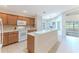 Kitchen boasts wood cabinets, breakfast bar, and view to backyard at 262 Hartford Ct, Spring Hill, FL 34609