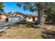 Tan house with a white garage door and landscaping at 29703 69Th N St, Clearwater, FL 33761