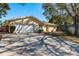 House exterior with a long driveway and a large tree at 29703 69Th N St, Clearwater, FL 33761