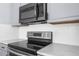 Stainless steel range and microwave in a kitchen with white tile backsplash at 3131 Deltona Blvd, Spring Hill, FL 34606