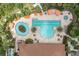 Aerial view of a community pool area with a pool, lazy river, jacuzzi, umbrellas and lounge chairs at 3312 Francoa Dr, Odessa, FL 33556