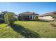 Well-maintained backyard with lush green lawn, mature landscaping, and a glimpse of a tile roof at 3312 Francoa Dr, Odessa, FL 33556