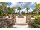 Relaxing fire pit area with stone seating and palm trees at 3312 Francoa Dr, Odessa, FL 33556
