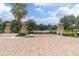 Gated community entrance with brick paved road and lush green landscaping at 3312 Francoa Dr, Odessa, FL 33556