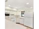 L-shaped kitchen with white appliances and a dishwasher at 5461 Colchester Ave, Spring Hill, FL 34608