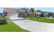 Two-car garage, driveway, and a well-maintained lawn at 7425 Nature Walk Dr, Spring Hill, FL 34606