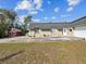 Tan house with a gray roof, white garage door, and landscaping at 7815 Tanglewood Dr, New Port Richey, FL 34654