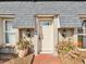 Light beige front door with sidelights and brick walkway at 7815 Tanglewood Dr, New Port Richey, FL 34654