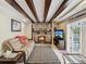 Cozy living room with a stone fireplace and exposed wooden beams at 7815 Tanglewood Dr, New Port Richey, FL 34654
