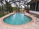 Inviting kidney-shaped pool with screened enclosure and brick deck at 8171 Chaucer Dr, Weeki Wachee, FL 34607