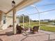 Enjoy the view from this screened porch with wicker furniture at 8730 Torchwood Dr, Trinity, FL 34655