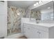 Modern bathroom featuring a marble-look shower and white cabinetry at 9126 Lester Ln, Spring Hill, FL 34606