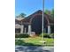 Community clubhouse with a flagpole and landscaping at 10736 Fiddlesticks Ct, New Port Richey, FL 34654