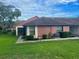 Red house exterior with landscaping and walkway at 10736 Fiddlesticks Ct, New Port Richey, FL 34654