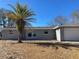 Gray house with a palm tree and gravel yard at 10929 Premier Ave, Port Richey, FL 34668