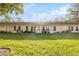 Back exterior view of villa, showcasing a well-maintained lawn and building at 11445 Orleans Ln, Port Richey, FL 34668
