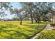 Landscaped grounds with mature oak trees and a winding path at 11445 Orleans Ln, Port Richey, FL 34668