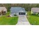 Cute one-story house with gray siding, screened porch and two-car garage at 11526 White Ash Dr, New Port Richey, FL 34654