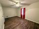 Bright bedroom with ceiling fan, wood-look floors, and red curtains at 13008 Fish Cove Dr, Spring Hill, FL 34609