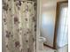 Bathroom with shower, toilet, and floral shower curtain at 15131 Eastwood Trl, Brooksville, FL 34604