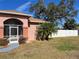 Brick house with screened porch and white fence at 15131 Eastwood Trl, Brooksville, FL 34604