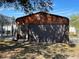 Detached garage with dark brown door and wood siding at 15131 Eastwood Trl, Brooksville, FL 34604