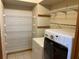 Laundry room with washer, dryer, and ample shelving at 15131 Eastwood Trl, Brooksville, FL 34604