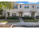 Tan three-story townhome with two-car garage and landscaping at 15933 Stable Run Dr, Spring Hill, FL 34610