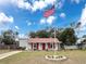 Charming one-story house with red accents and American flag at 1661 Larkin Rd, Spring Hill, FL 34608