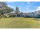House exterior showcasing a large lawn and beautiful landscaping at 2595 Royal Liverpool Dr, Tarpon Springs, FL 34688