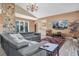 Spacious living room featuring a stone fireplace and large sectional sofa at 2595 Royal Liverpool Dr, Tarpon Springs, FL 34688