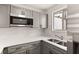 Modern kitchen with gray cabinets and a double sink at 4712 Stonepointe Pl, Tampa, FL 33634
