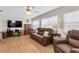 Living room featuring brown leather reclining furniture and large TV at 4737 Sandpointe Dr, New Port Richey, FL 34655