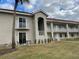 Tan two-story building with balconies, and a grassy yard at 6734 Dali Ave # 206, Land O Lakes, FL 34637