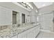 Bathroom with granite countertop, double sinks, and a large shower at 8148 Ambersweet Pl, Land O Lakes, FL 34637