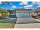 House exterior features a light teal color, two-car garage, and landscaping at 8148 Ambersweet Pl, Land O Lakes, FL 34637