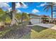 Landscaped yard with tropical plants and a two-car garage at 8148 Ambersweet Pl, Land O Lakes, FL 34637