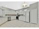 White kitchen with stainless steel appliances and tile flooring at 8148 Ambersweet Pl, Land O Lakes, FL 34637