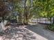 Landscaped backyard with mature trees and a white fence at 8177 Philatelic Dr, Spring Hill, FL 34606