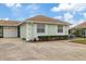 Front view of a light green villa with a brown roof, well-maintained landscaping, and a garage at 8350 High Point Cir # 3, Port Richey, FL 34668