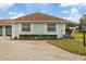 Light green villa with brown roof, landscaping, and a carport at 8350 High Point Cir # 3, Port Richey, FL 34668